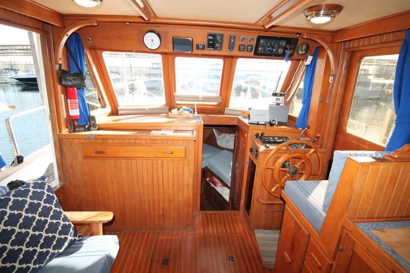 Slide: The Image of 1986 Senator 35 Sundeck Trawler interior with wooden helm, seating, and nautical decor. - 20