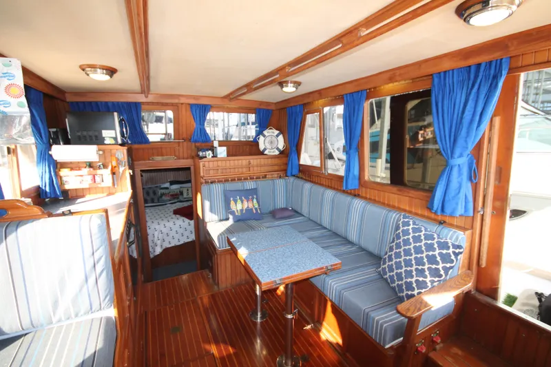 Slide: The Image of Interior of 1986 Senator 35 Sundeck Trawler with blue upholstery and wooden accents. - 22