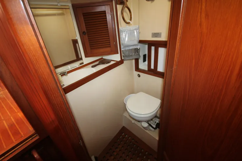 Slide: The Image of 1986 Senator 35 Sundeck Trawler bathroom with wooden accents and compact design. - 24