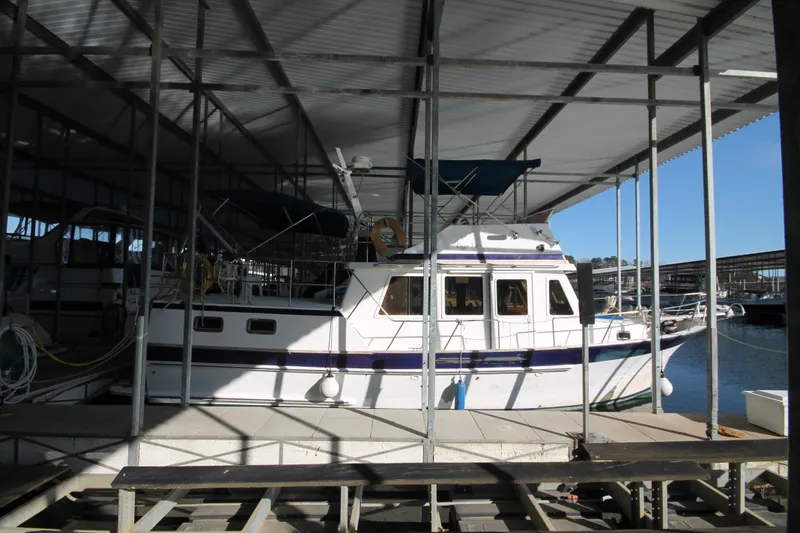 Slide: The Image of 1986 Senator 35 Sundeck Trawler docked under a covered marina. - 3