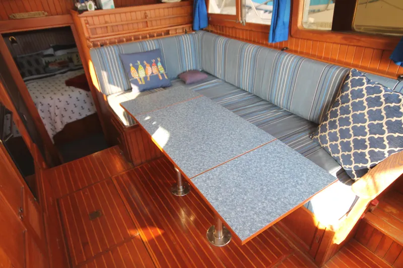 Slide: The Image of 1986 Senator 35 Sundeck Trawler interior with striped seating and wooden flooring. - 30
