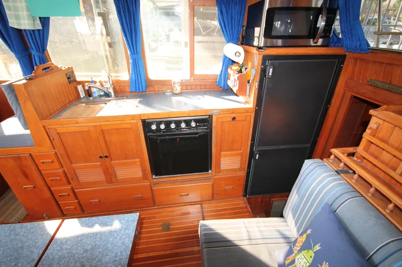 Slide: The Image of Interior of 1986 Senator 35 Sundeck Trawler with wooden cabinetry and kitchen appliances. - 31