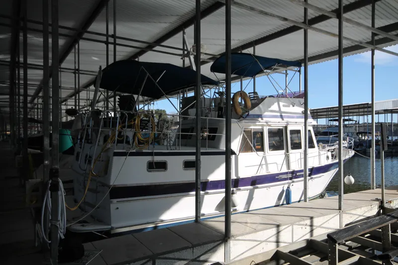 Slide: The Image of 1986 Senator 35 Sundeck Trawler docked in a covered marina. - 4