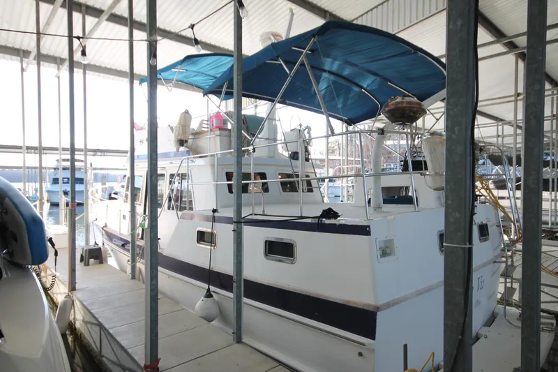 Slide: The Image of 1986 Senator 35 Sundeck Trawler docked in a covered marina. - 5