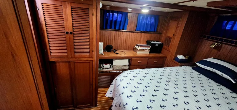 Slide: The Image of Cozy cabin interior of 1986 Senator 35 Sundeck Trawler with wood paneling and nautical bedding. - 50