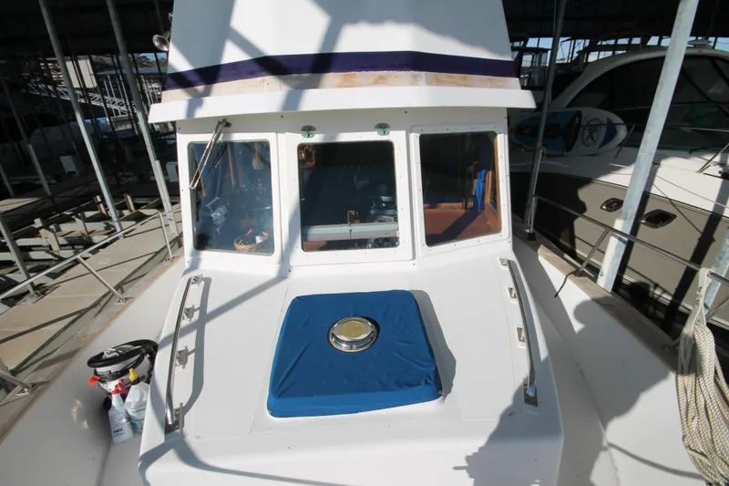 Slide: The Image of 1986 Senator 35 Sundeck Trawler, docked, showcasing front deck and cabin windows. - 8