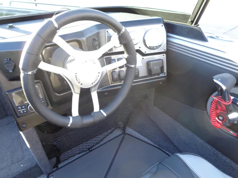 Slide: The Image of 2025 Lund 1875 Tyee boat interior with steering wheel and dashboard controls. - 18
