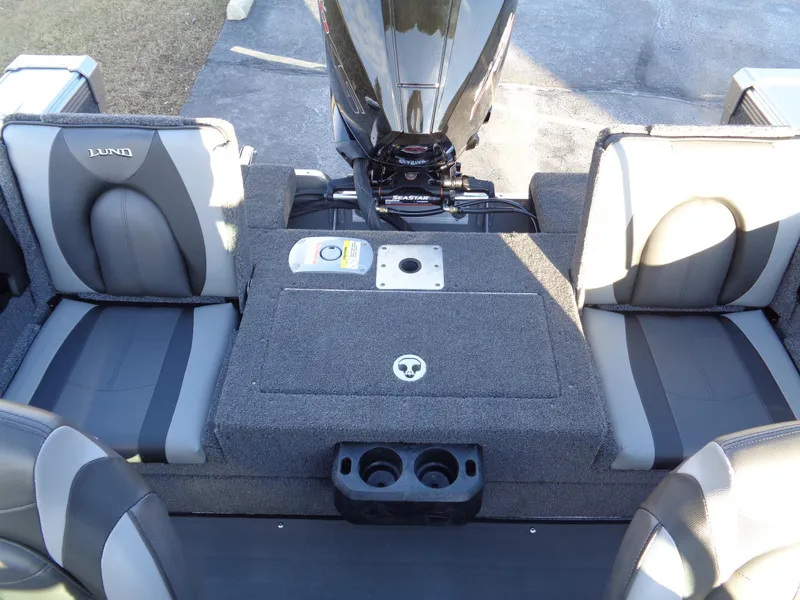 Slide: The Image of 2025 Lund 1875 Tyee boat interior with seating and motor, featuring gray upholstery. - 22