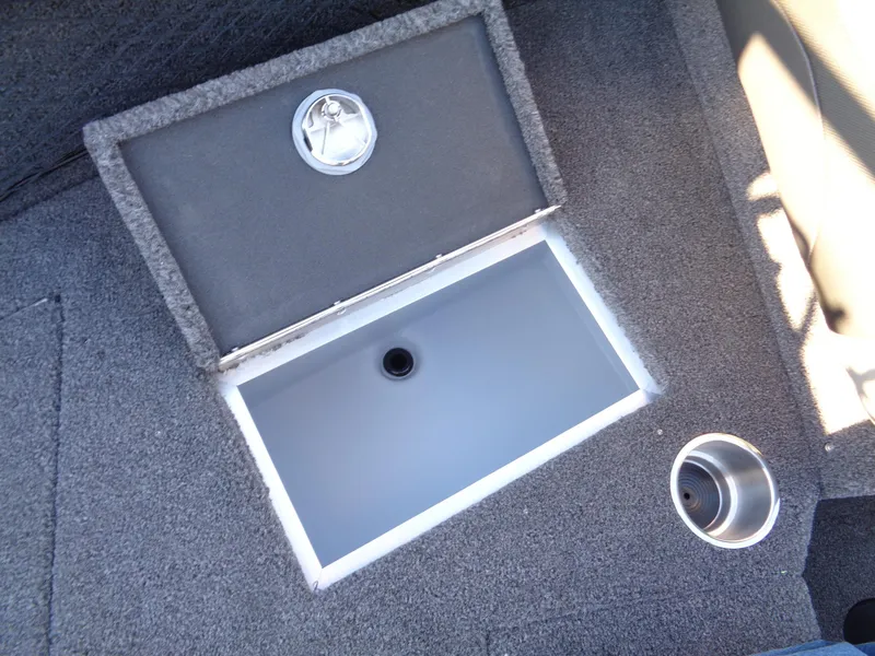 Slide: The Image of 2025 Lund 1875 Tyee boat storage compartment with carpeted interior and cup holder. - 28