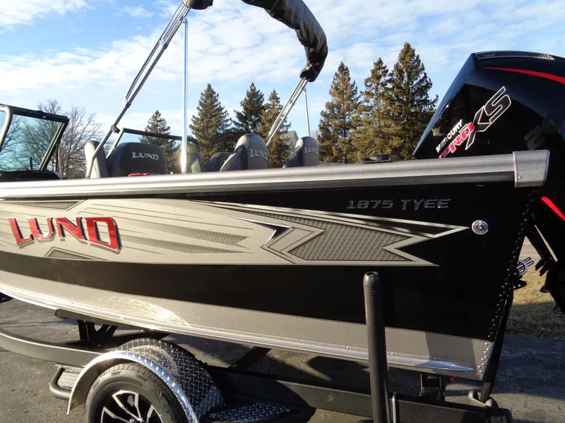 Slide: The Image of 2025 Lund 1875 Tyee boat with Mercury Pro XS engine, parked outdoors. - 3