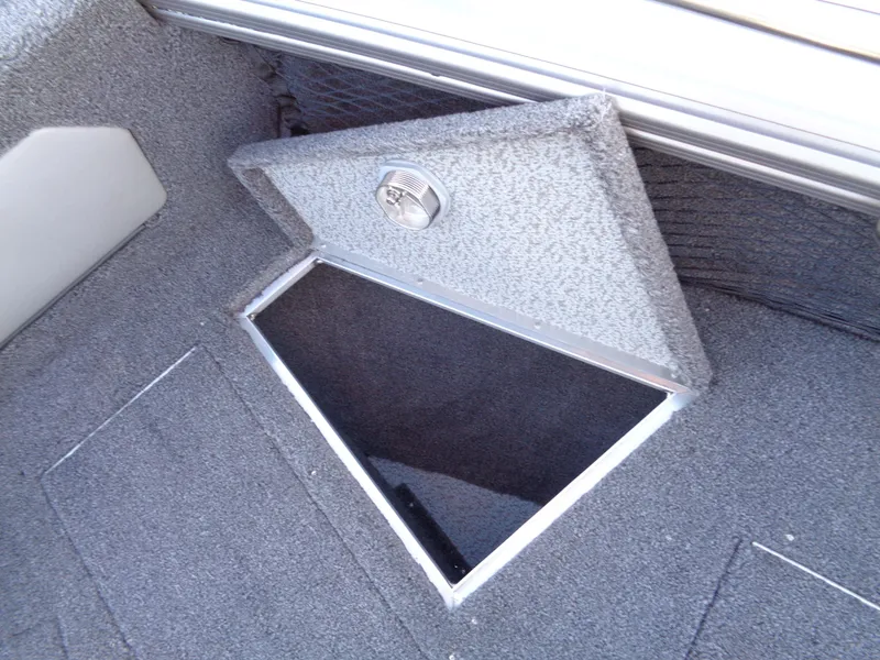 Slide: The Image of 2025 Lund 1875 Tyee boat storage compartment with open hatch, carpeted interior. - 30
