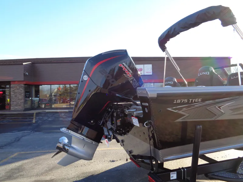 Slide: The Image of 2025 Lund 1875 Tyee boat with powerful outboard motor in a parking lot. - 5