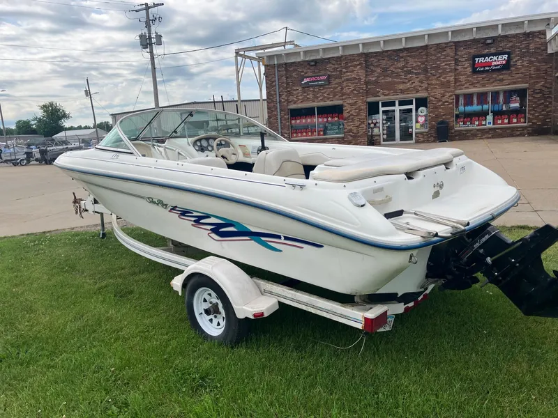 Slide: The Image of 1996 Sea Ray 175 Open Bow boat on trailer, parked on grass near a brick building. - 5