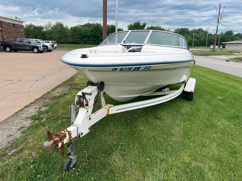 Slide: The Image of 1996 Sea Ray 175 Open Bow boat on trailer, parked on grass under cloudy sky. - 3