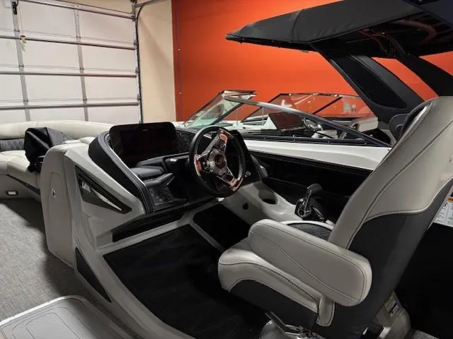 Slide: The Image of 2026 Barletta L25MA boat interior with modern steering and seating in a showroom. - 11