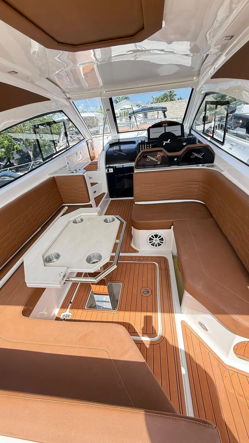 Slide: The Image of 2025 NX Boats NX370 HT interior with brown seating and modern design. - 4