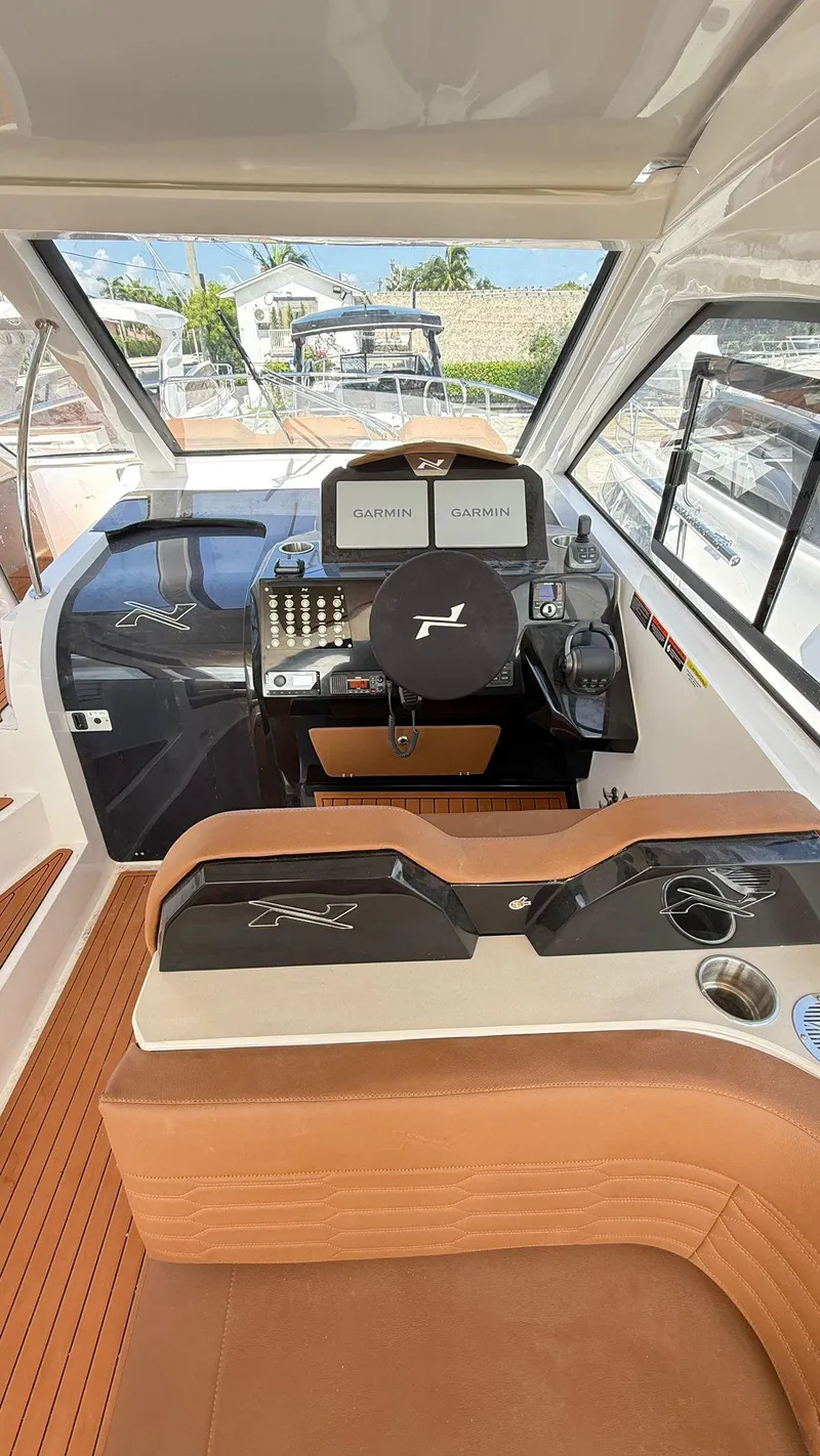 Slide: The Image of 2025 NX Boats NX370 HT helm with Garmin displays, luxurious seating, and modern controls. - 6