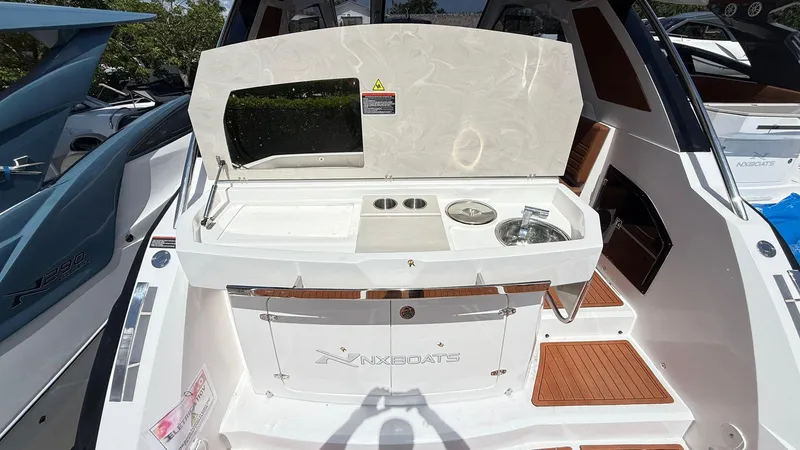 Slide: The Image of 2025 NX Boats NX370 HT with outdoor kitchenette and sink on deck. - 7