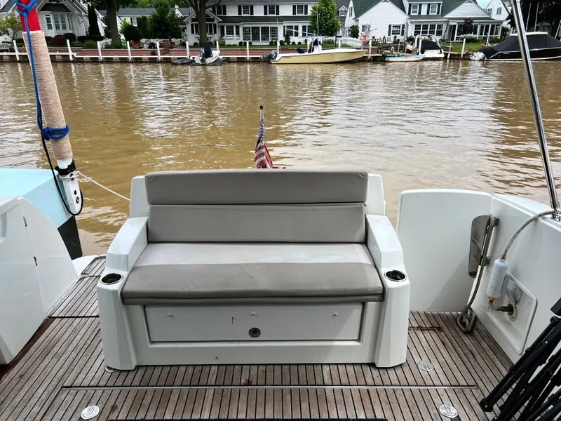 Slide: The Image of 2017 Jeanneau NC11 boat with rear seating, docked by waterfront homes. - 10