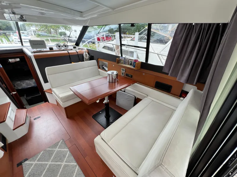 Slide: The Image of Interior of 2017 Jeanneau NC11 yacht with elegant seating and wooden table. - 13