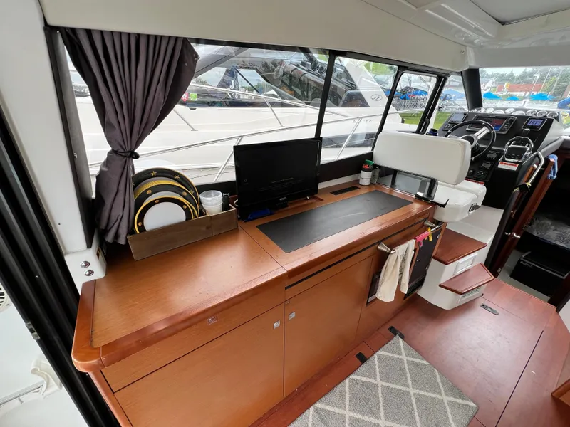 Slide: The Image of Interior of 2017 Jeanneau NC11 yacht with helm, wooden cabinetry, and modern design elements. - 16