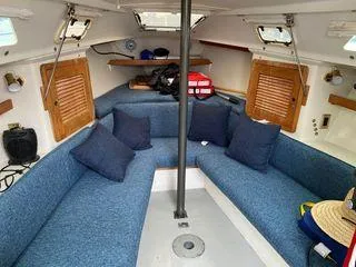 Slide: The Image of 1994 Catalina 270 LE sailboat interior with blue seating and wooden accents. - 27
