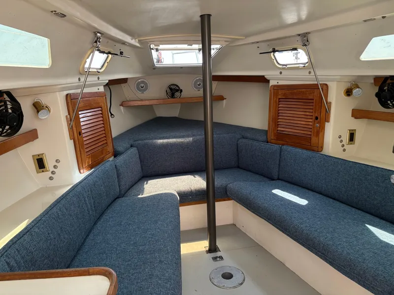 Slide: The Image of Interior of 1994 Catalina 270 LE sailboat with blue seating and wooden accents. - 29