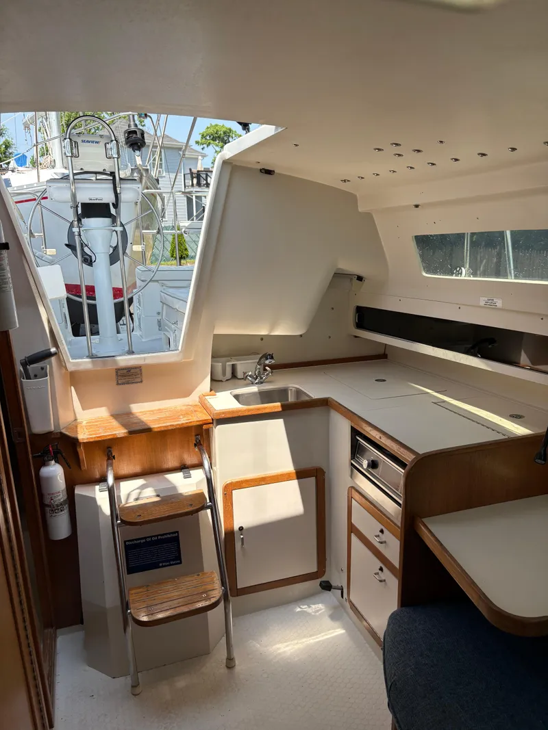 Slide: The Image of Interior of 1994 Catalina 270 LE sailboat with compact kitchen and seating area. - 36