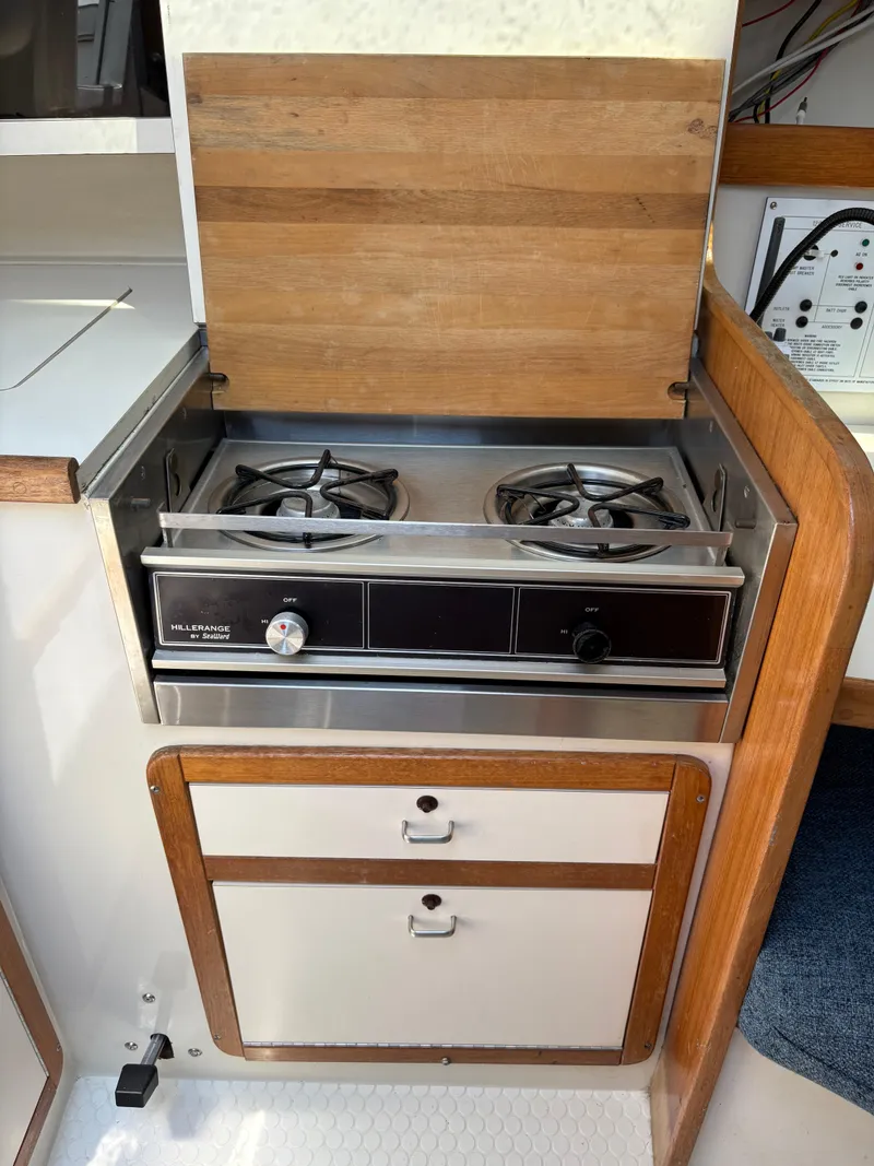 Slide: The Image of Catalina 270 LE 1994 boat kitchen with two-burner stove and wooden cabinetry. - 37