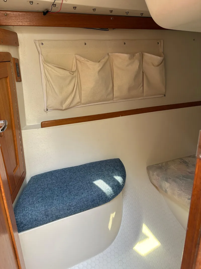 Slide: The Image of Interior of a 1994 Catalina 270 LE sailboat with blue cushion and storage pockets. - 38