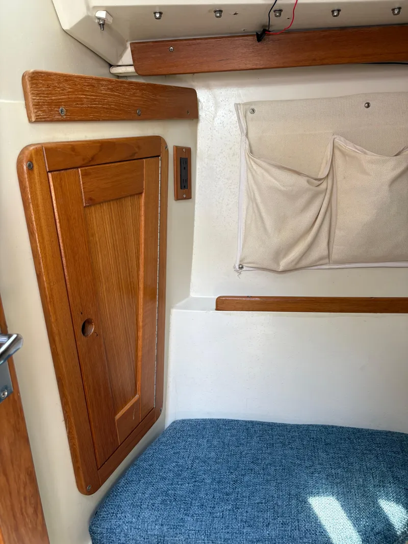 Slide: The Image of Interior of a 1994 Catalina 270 LE sailboat with wooden cabinetry and blue cushion. - 40
