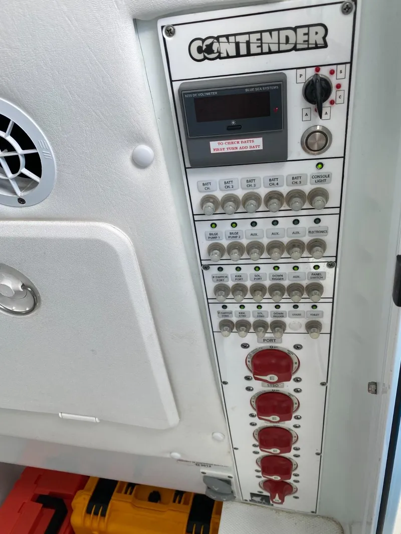 Slide: The Image of Control panel of a 2017 Contender 35 Tournament boat with switches and dials. - 22
