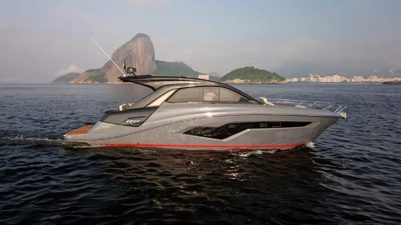 Slide: The Image of 2025 NX Boats NX44 PININFARINA cruising on scenic waters with mountainous backdrop. - 5