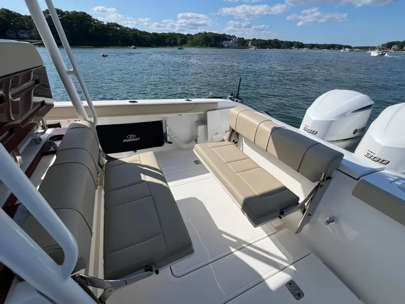 Slide: The Image of 2019 Pursuit S 288 boat interior with seating, twin Yamaha 300 engines, and scenic water view. - 14