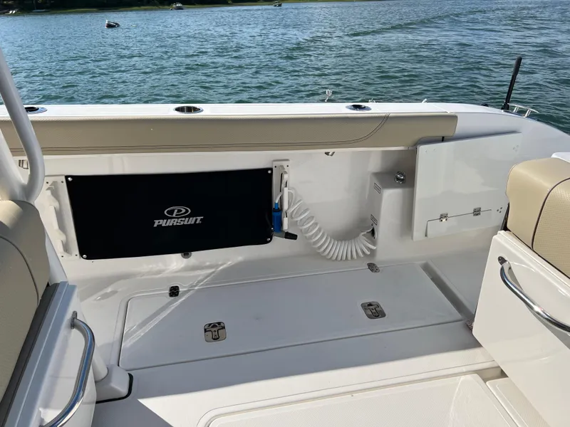 Slide: The Image of 2019 Pursuit S 288 boat interior with seating and storage, overlooking a serene lake. - 17