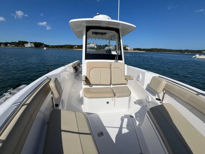 Slide: The Image of 2019 Pursuit S 288 boat with beige seating, on calm water under clear blue sky. - 7