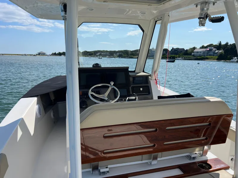 Slide: The Image of 2019 Pursuit S 288 boat interior with steering wheel, dashboard, and scenic water view. - 9