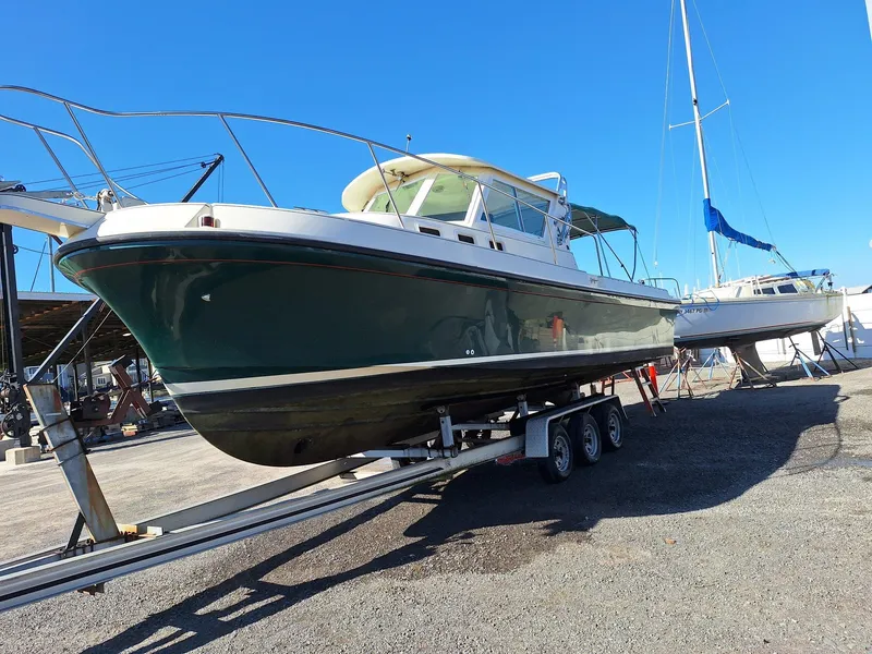 Slide: The Image of 1997 Albin 28 TE boat on trailer, parked outdoors under clear blue sky. - 26