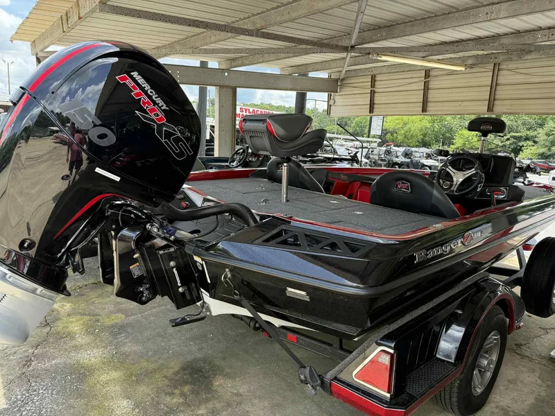 Slide: The Image of 2022 Ranger Z518 boat with Mercury Pro XS engine, parked under a metal canopy. - 2