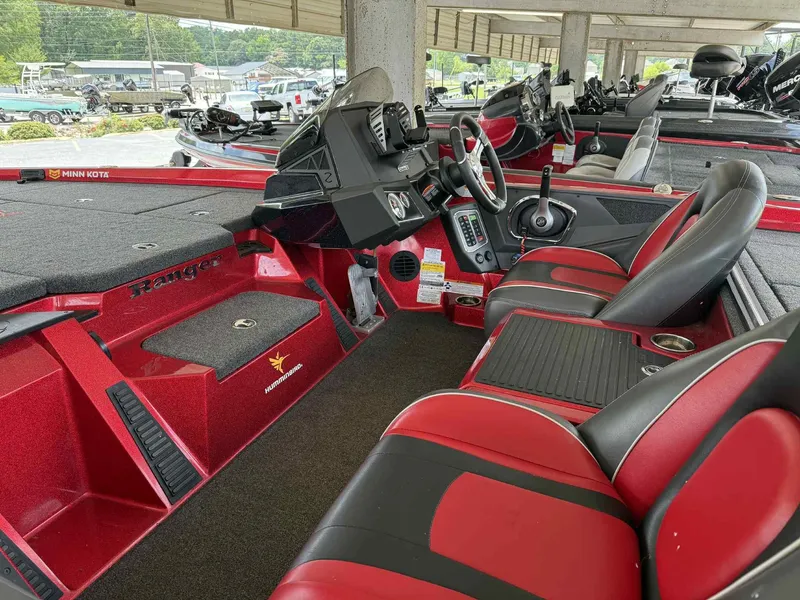 Slide: The Image of 2022 Ranger Z518 boat interior with red and black seating, steering console, and fishing equipment. - 4