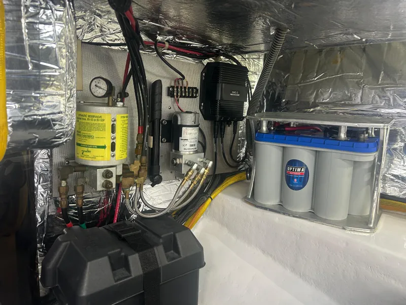 Slide: The Image of Electrical and mechanical components inside a 1996 Tides 27 boat, featuring Optima battery. - 11