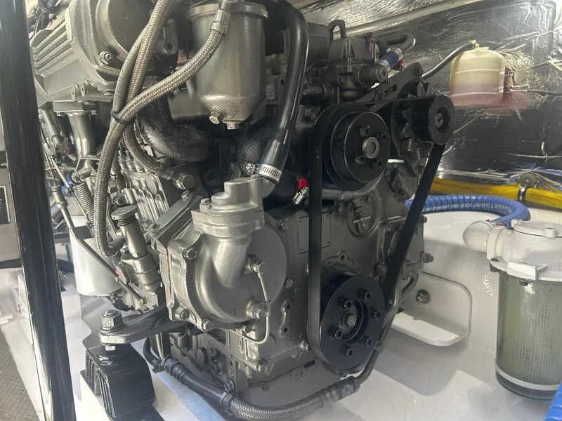 Slide: The Image of Engine of a 1996 Tides 27 boat, showcasing mechanical components and hoses. - 13