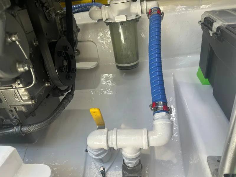 Slide: The Image of Engine compartment of a 1996 Tides 27 boat with blue hose and filter system. - 15