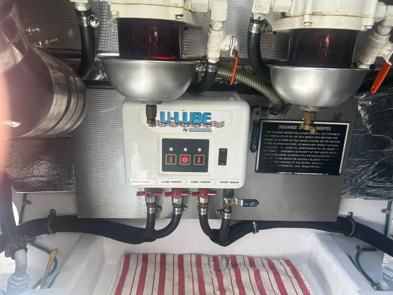 Slide: The Image of Engine compartment of a 1996 Tides 27 boat with U-Lube system and discharge warning sign. - 19