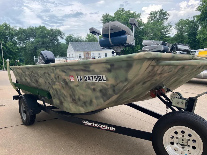 Slide: The Image of Camouflage-patterned 2012 Steven Custom JON EXTRA WIDE boat on trailer, parked outdoors. - 12