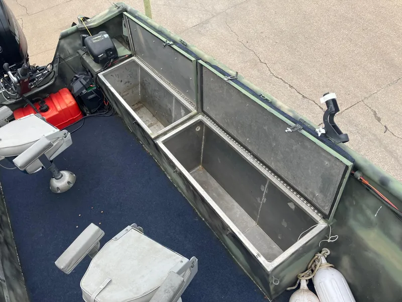 Slide: The Image of Open storage compartments on a 2012 Steven Custom JON EXTRA WIDE boat with seating and equipment. - 13