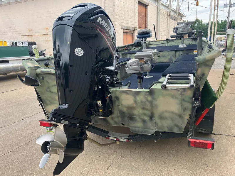 Slide: The Image of 2012 Steven Custom JON EXTRA WIDE boat with Mercury outboard motor, parked outdoors. - 23