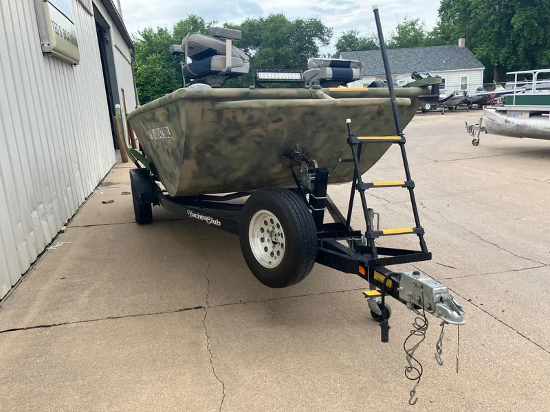 Slide: The Image of 2012 Steven Custom JON EXTRA WIDE boat on trailer, camo design, parked outdoors. - 6