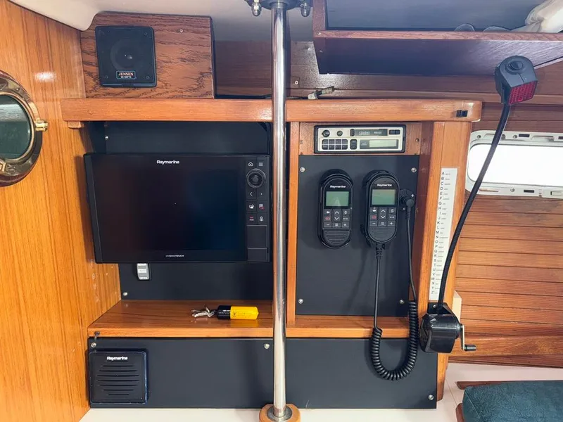 Slide: The Image of Navigation equipment on a 1998 Catalina 42Mk 2 sailboat, featuring Raymarine displays and communication devices. - 11