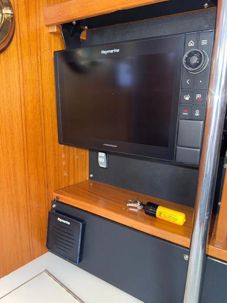 Slide: The Image of Raymarine navigation system inside 1998 Catalina 42Mk 2 yacht, featuring wood paneling and equipment. - 14